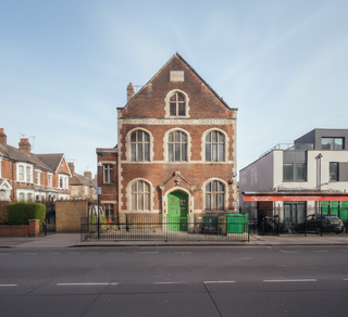 Brick building with a green door on a street corner,晴朗的天空